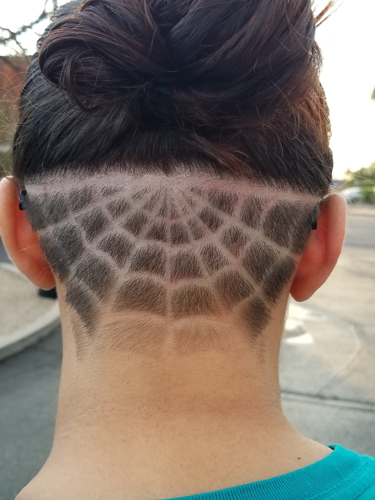 Freestyle spider web design shaved into the back of an undercut