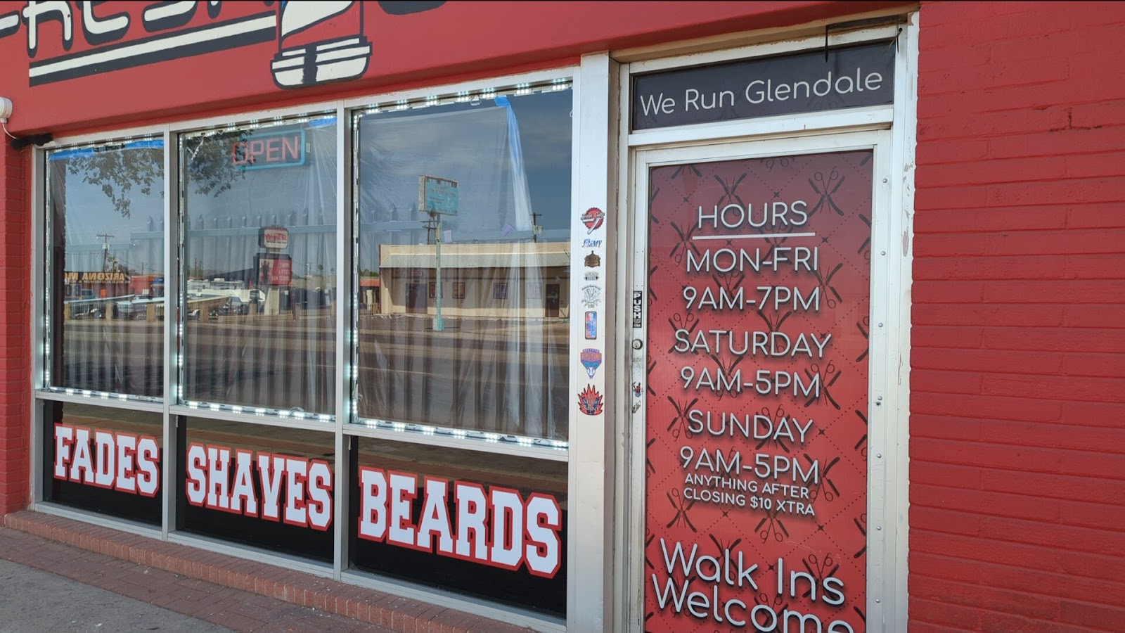 Our red storefront on Glendale Ave: FADES SHAVES BEARDS across the glass, hours and Walk Ins Welcome on the door